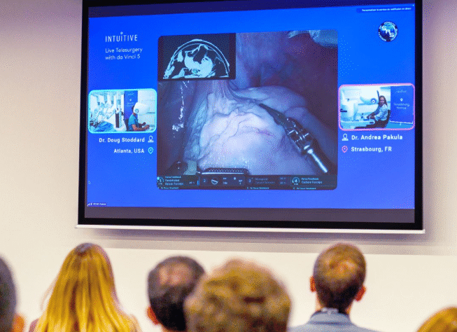 Attendees at the Society of Robotic Surgery observe a live telesurgery demonstration by Intuitive Surgical.