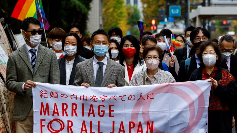 Plaintiffs and supporters outside the Tokyo courthouse holding protest signs after the high court upholds Japan’s same-sex marriage ban.