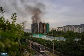 Flames engulfing multiple high-rise apartments in Hong Kong’s Wang Fuk Court, with residents watching from a safe distance as firefighters battle the blaze.