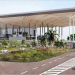 Aerial view of Yamuna Expressway near the upcoming Jewar Airport, with developing real estate projects and vacant land parcels.