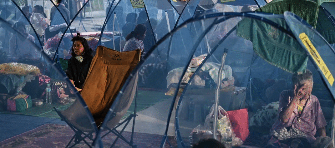 A person carrying a child at a refugee camp after evacuation in Srei Snam, Cambodia, during Thailand-Cambodia clashes.