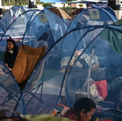 A person carrying a child at a refugee camp after evacuation in Srei Snam, Cambodia, during Thailand-Cambodia clashes.