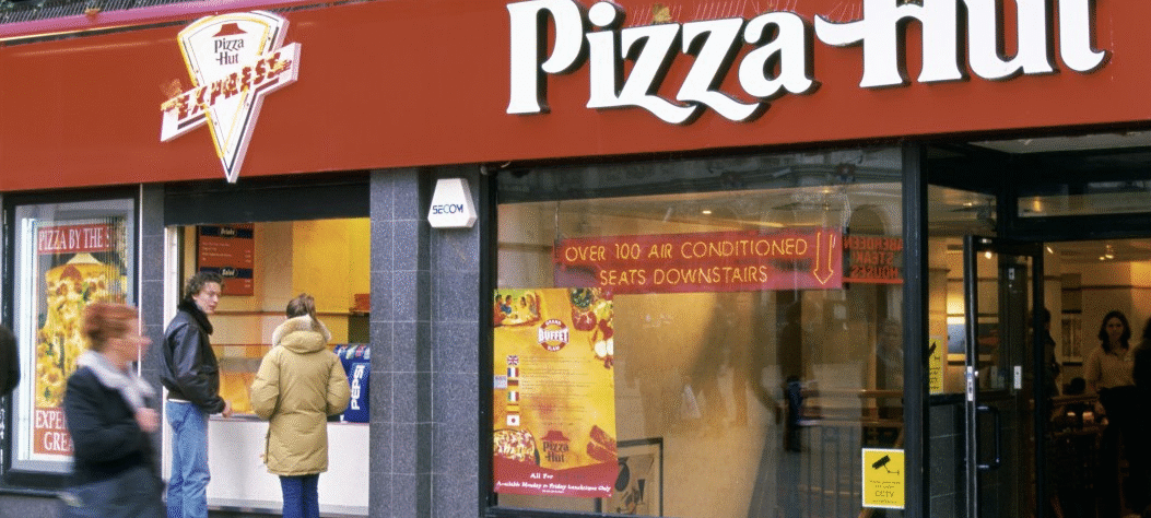 Pizza Hut restaurant with iconic red roof and branding, representing the global pizza chain.