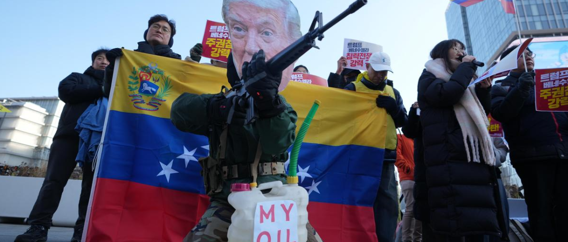 Man wearing Donald Trump mask holding mock gun at anti-U.S. rally near U.S. Embassy in Seoul, January