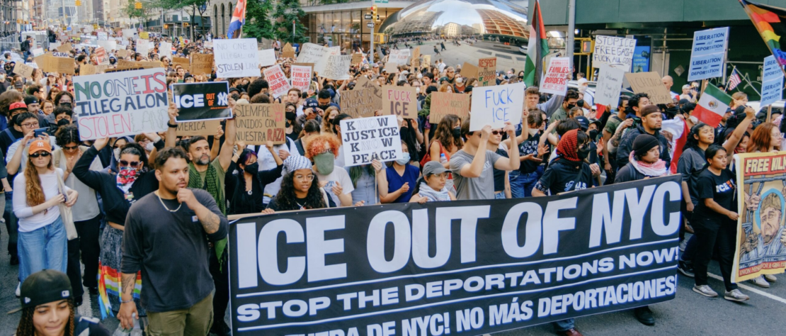 Protesters hold signs opposing ICE raids during a demonstration against immigration enforcement policies in a U.S. city, early 2026.