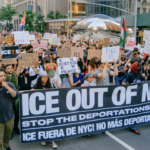 Protesters hold signs opposing ICE raids during a demonstration against immigration enforcement policies in a U.S. city, early 2026.